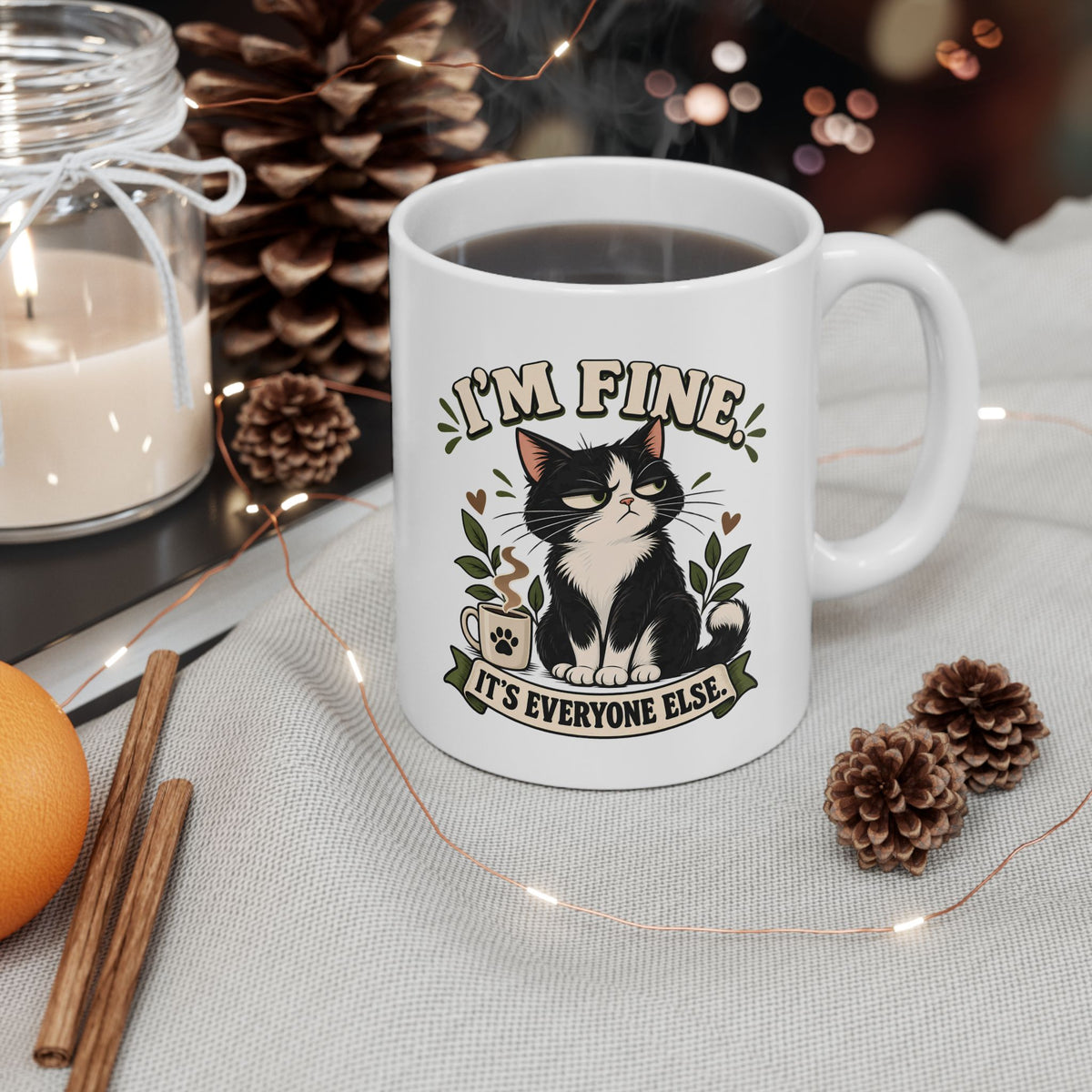I'm Fine sarcastic cat mug in a cozy setting with pinecones and warm lights